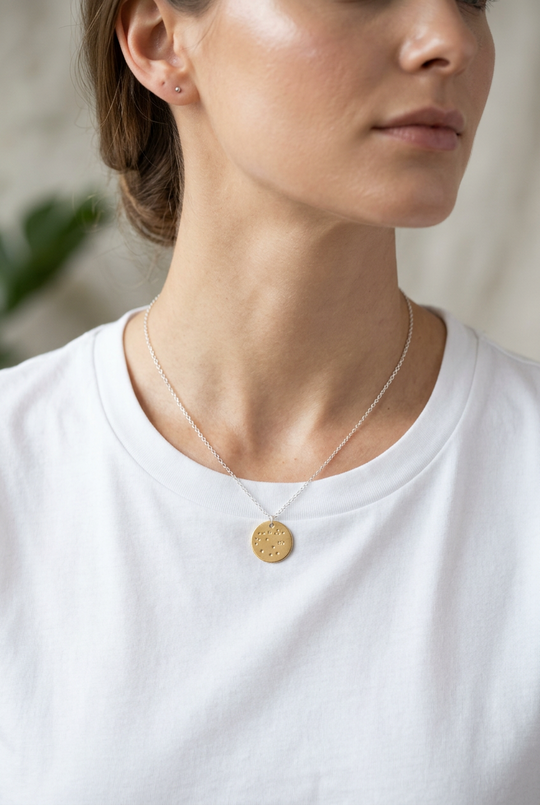 hand stamped constellation disk on a woman