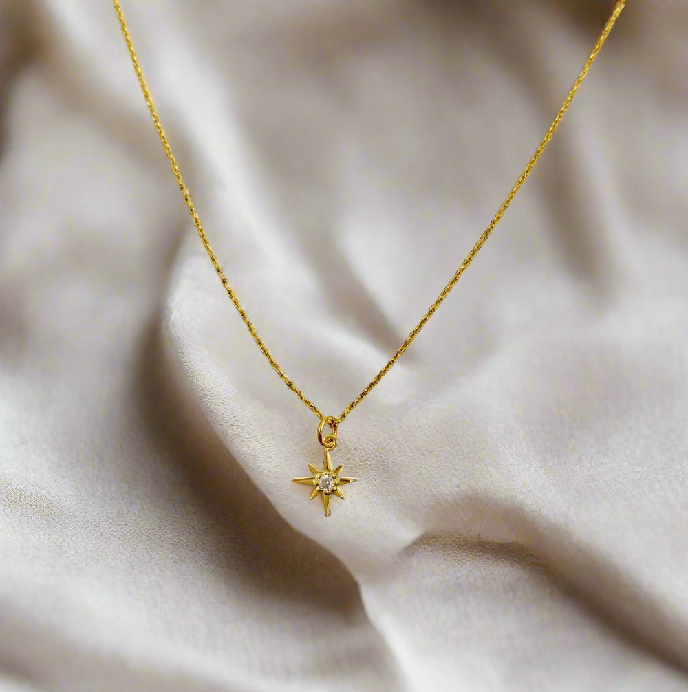 14K Gold Eight Point Star Charm Necklace, our dainty gold star necklace has an eight-point star charm with a cubic zirconia center on a 14k gold-filled chain