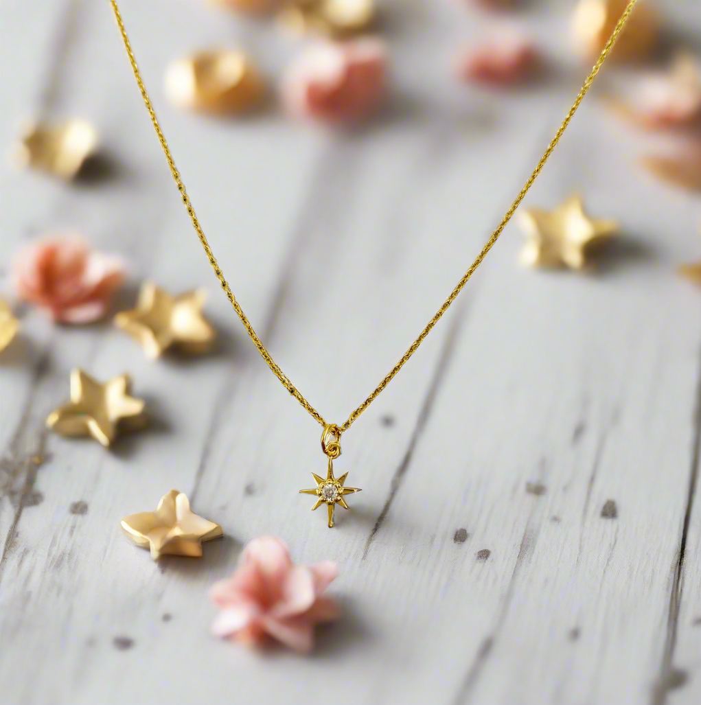 14K Gold Eight Point Star Charm Necklace, our dainty gold star necklace has an eight-point star charm with a cubic zirconia center on a 14k gold-filled chain