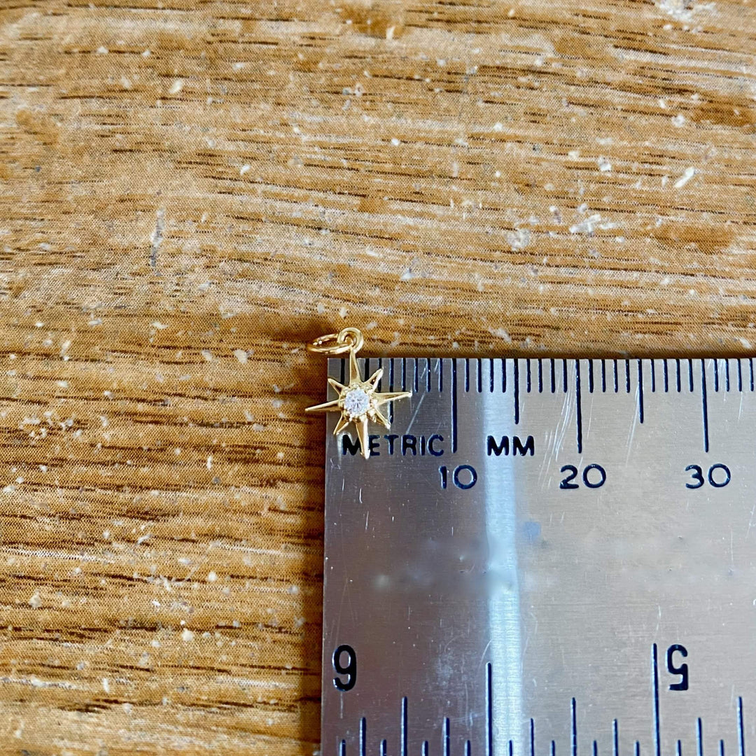 14K Gold Eight Point Star Charm Necklace, our dainty gold star necklace has an eight-point star charm with a cubic zirconia center on a 14k gold-filled chain