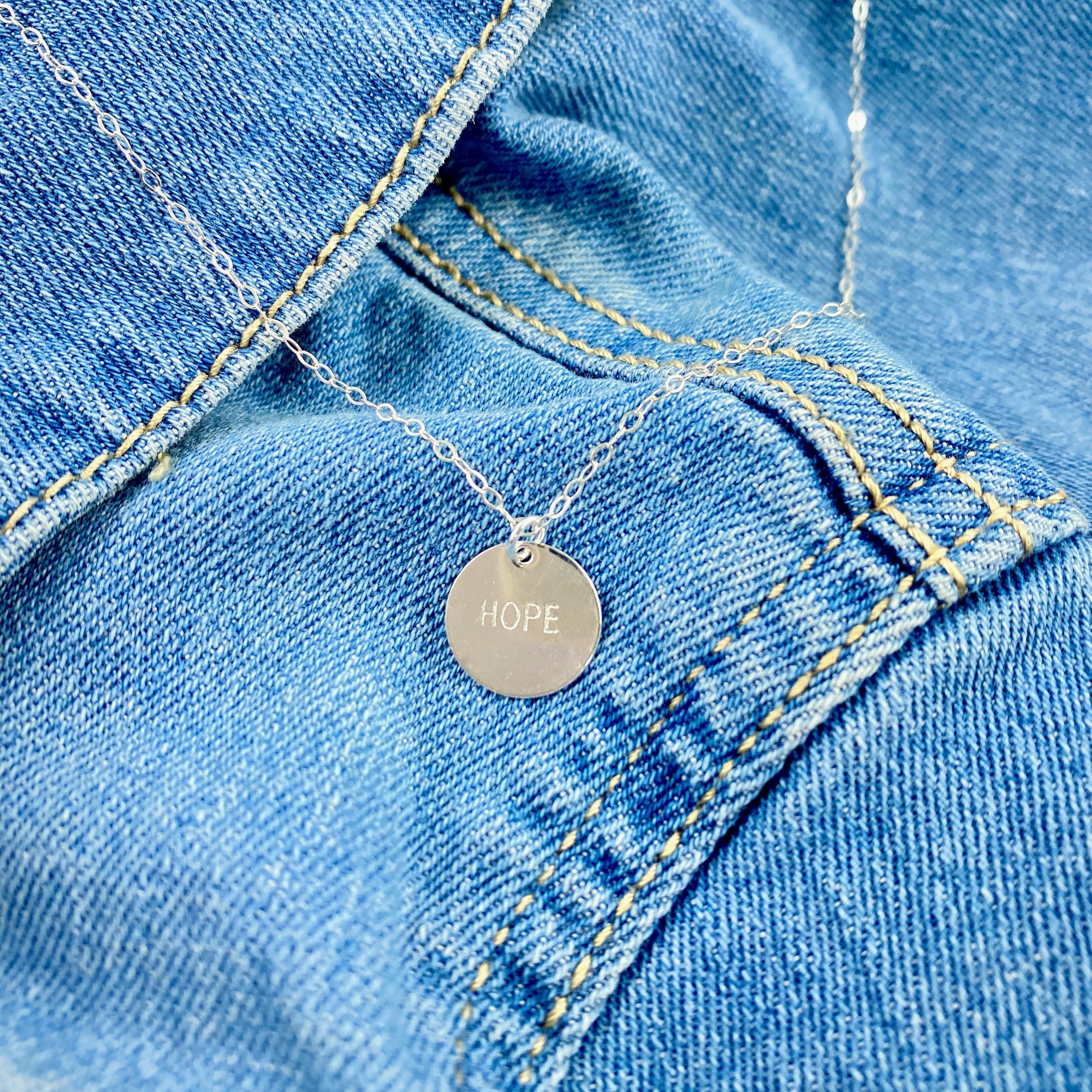 Silver Hand Stamped HOPE Necklace, our delicate gold disk necklace features a hand stamped "HOPE" message in simple script. Its minimalist design and it's delicate chain add a sweet, subtle touch making it a treasure to adore.