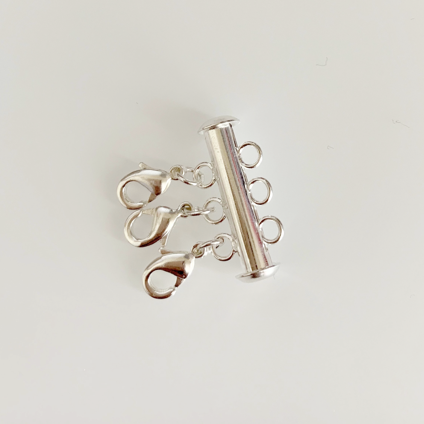 Silver Necklace Spacer Tube For Three Necklaces, our necklace spacer lets you layer three necklaces without tangling. It has three small silver-plated lobster clasps 