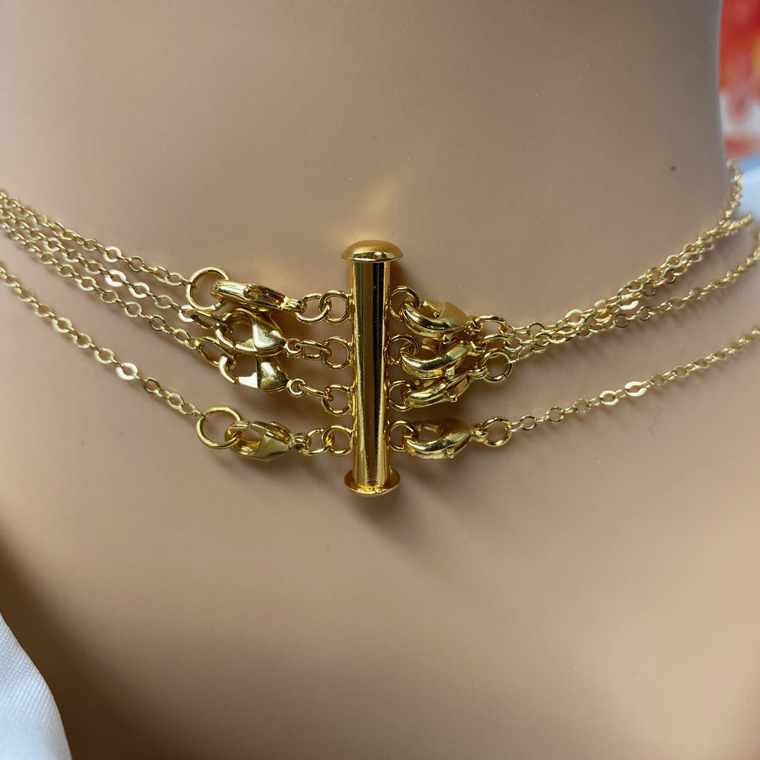 Gold Necklace Spacer Tube For Four Necklaces, our necklace spacer lets you layer up to four necklaces without tangling. It features four small gold-plated lobster clasps 