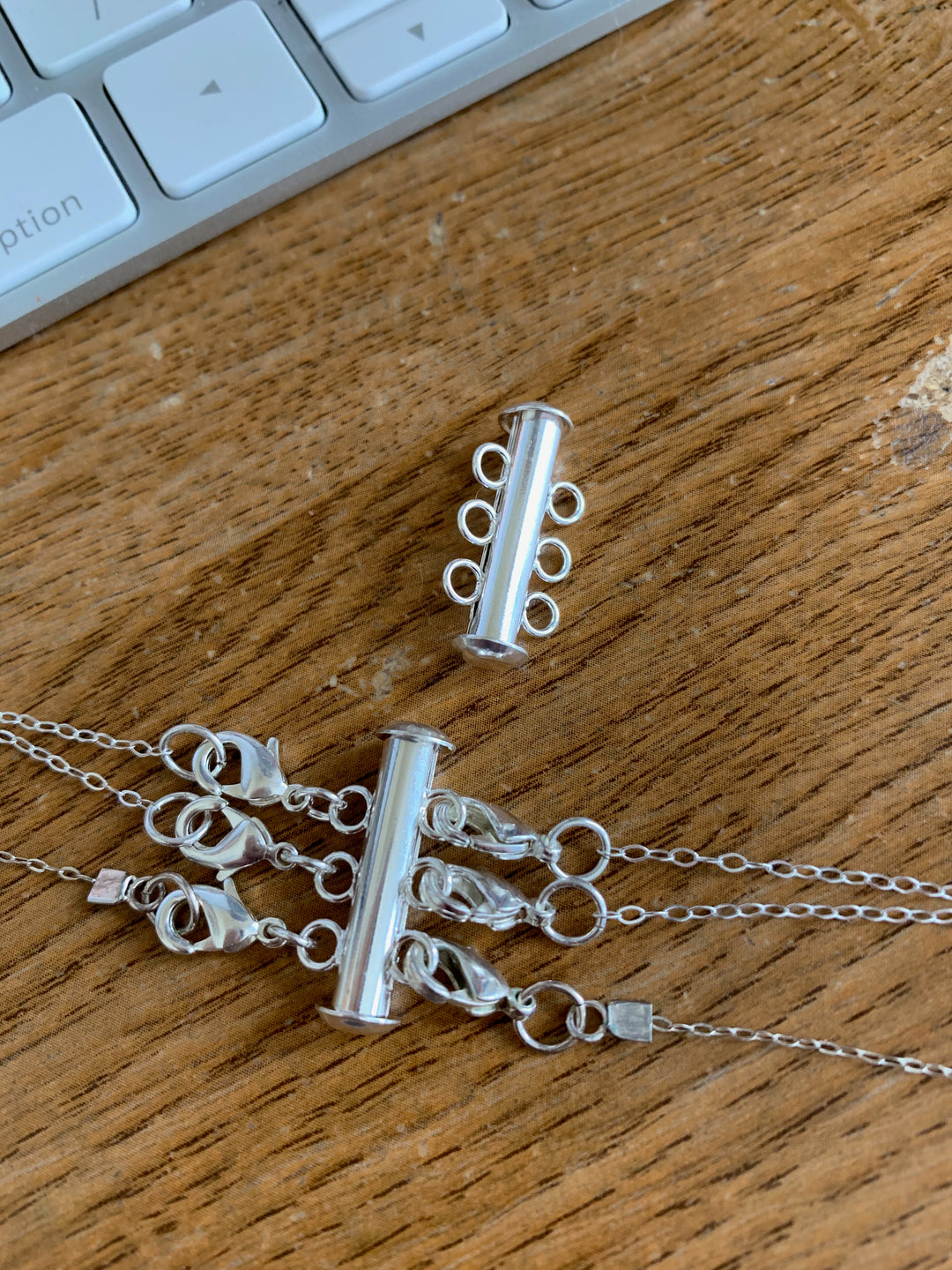 Silver Necklace Spacer Tube For Three Necklaces, our necklace spacer lets you layer three necklaces without tangling. It has three small silver-plated lobster clasps 