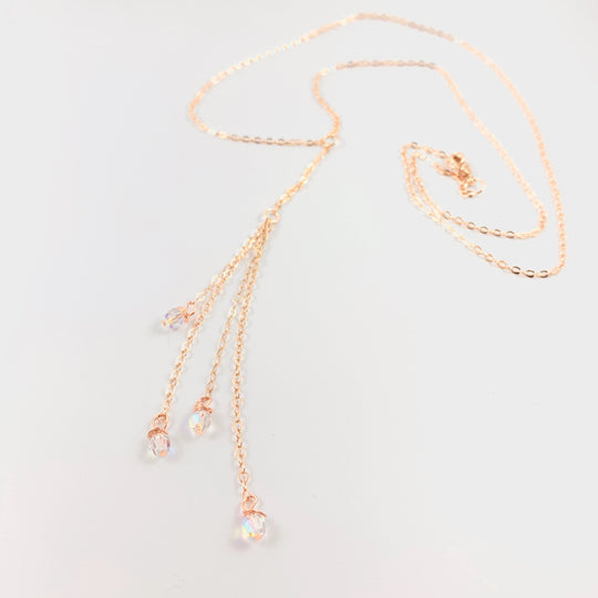 Evening Crystal Sparkle Rose Gold Lariat is our unique design made to be Sweet & Petite is just that. The Rose Gold Lariat chain leads to four dangling chain strands with four sparkling clear crystals to finish the ends. 