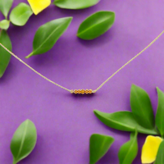 Topaz Orange Crystal Bar Necklace, this necklace has five tiny crystals on a 14k gold-filled chain. Petite and charming, it adds a subtle sparkle.