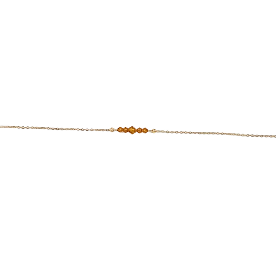 Topaz Orange Crystal Bar Necklace, this necklace has five tiny crystals on a 14k gold-filled chain. Petite and charming, it adds a subtle sparkle.
