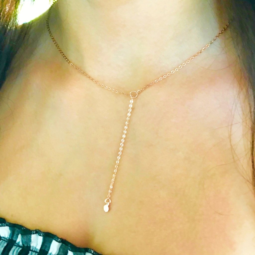 Rose Gold Dot Lariat Charm Necklace, a tiny rose gold dot charm hangs from the sparkling rose gold chain as a lariat with a petite rose gold circle for the slide through