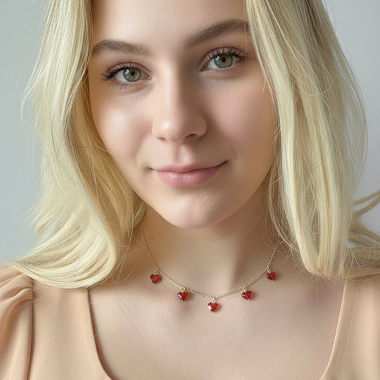 This Ruby Red Crystal Heart Necklace is irresistibly sweet and petite, featuring five tiny heart-shaped crystals wire wrapped on a sterling silver chain 